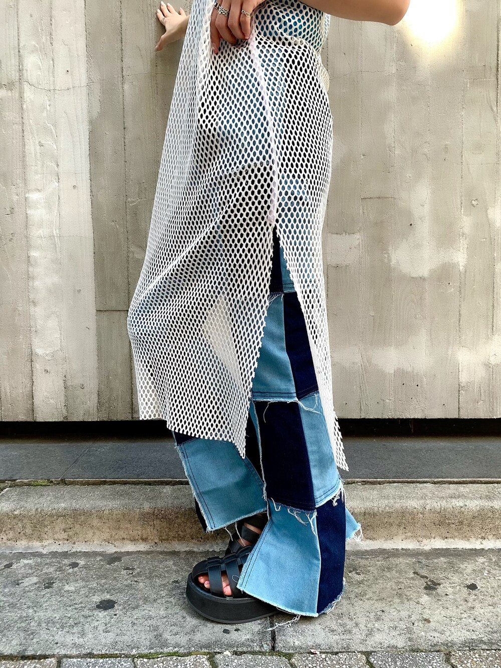 ブルー系のタンクトップ、ホワイト系のワンピース、ブルー系のデニムパンツを着用したレディースの夏コーディネートの3枚目の写真