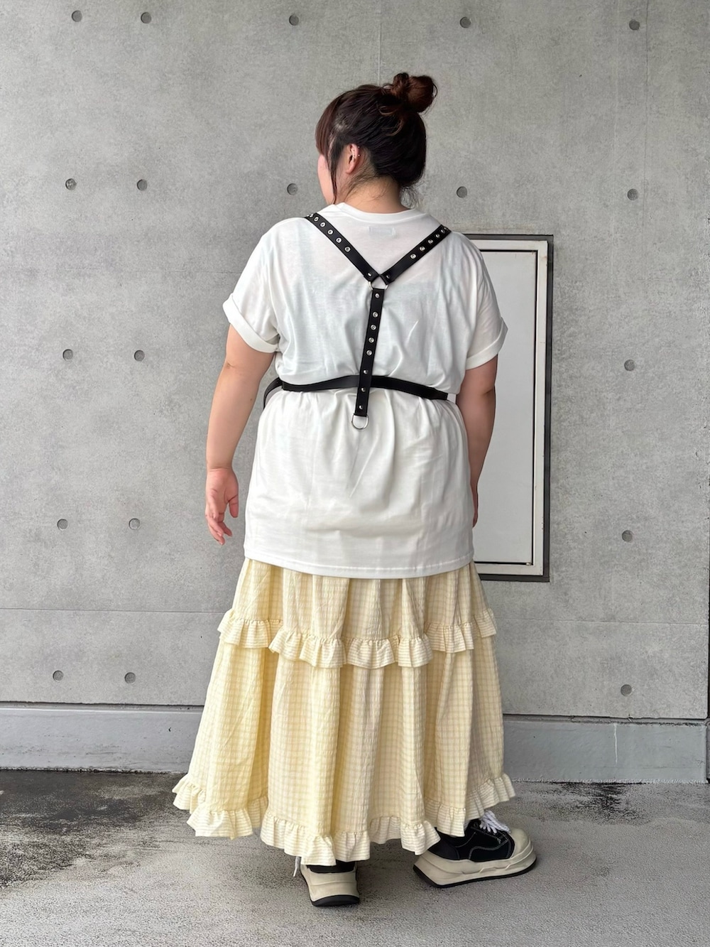 イエロー系のスカート、ホワイト系のTシャツ/カットソー、ブラック系のベルトを着用したレディースの夏コーディネートの5枚目の写真