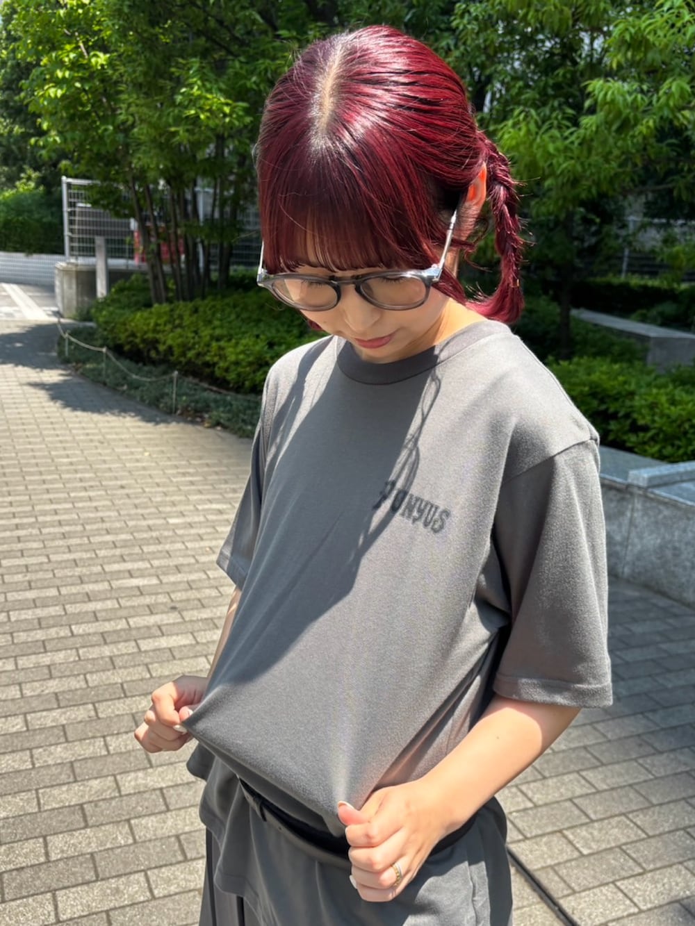 グレー系のスカート、ブラック系のデニムパンツ、ブラック系のTシャツ/カットソーを着用したレディースの夏コーディネートの6枚目の写真