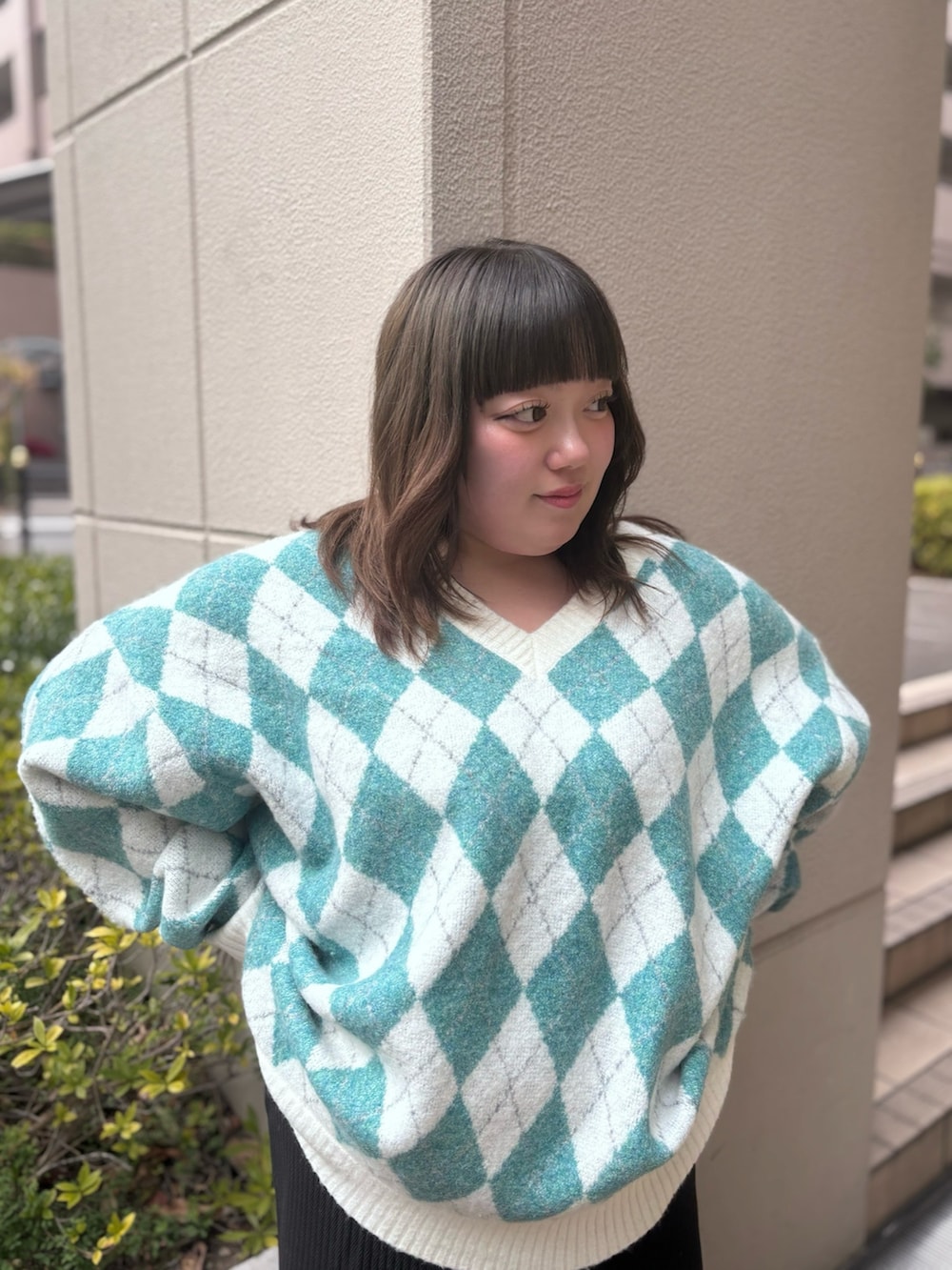 グリーン系のニット/セーター、ブラック系のスカートを着用したレディースの冬コーディネートの4枚目の写真