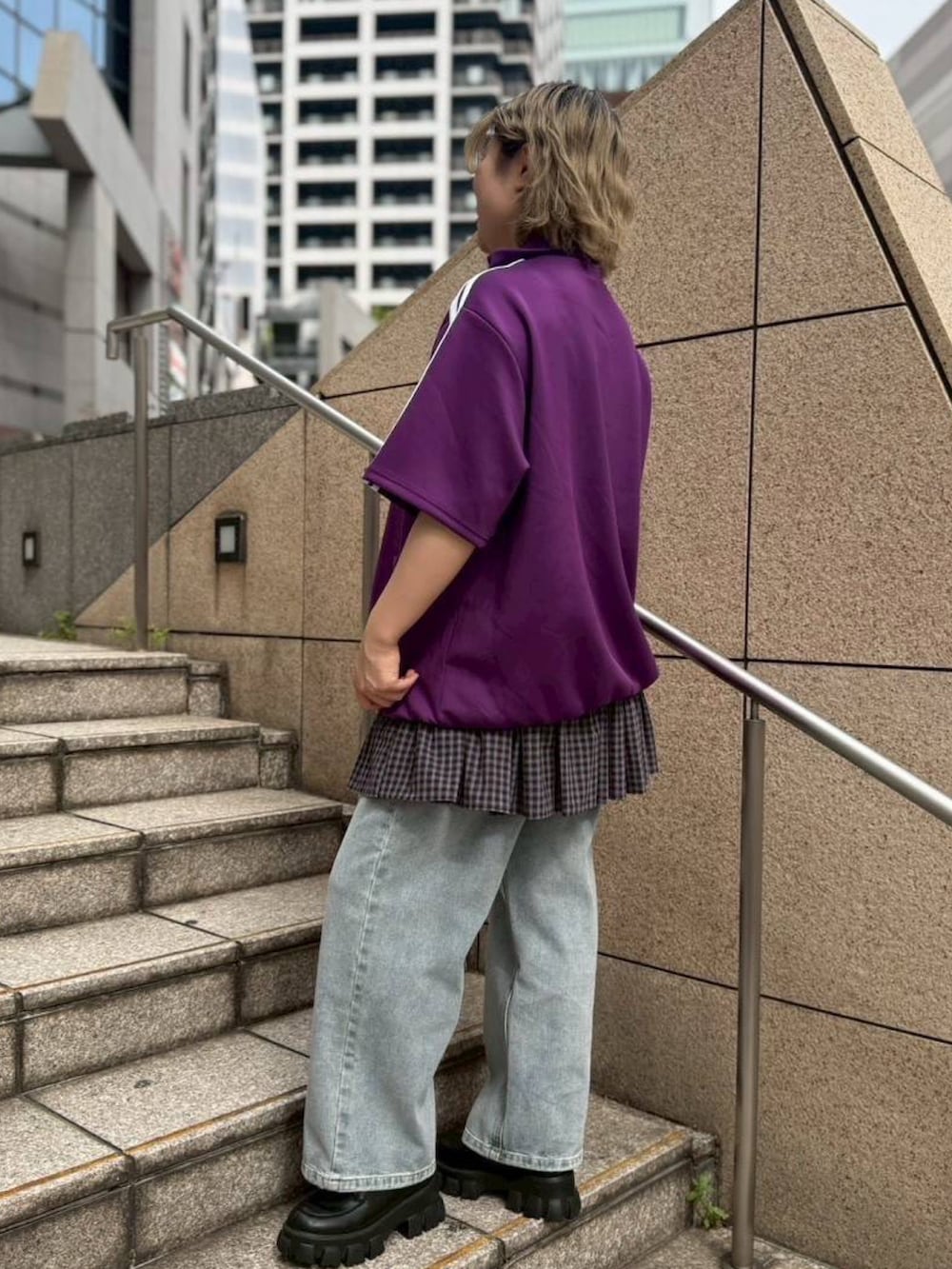 パープル系のジャージ、ブルー系のスカート、ブルー系のデニムパンツを着用したレディースの春コーディネートの5枚目の写真