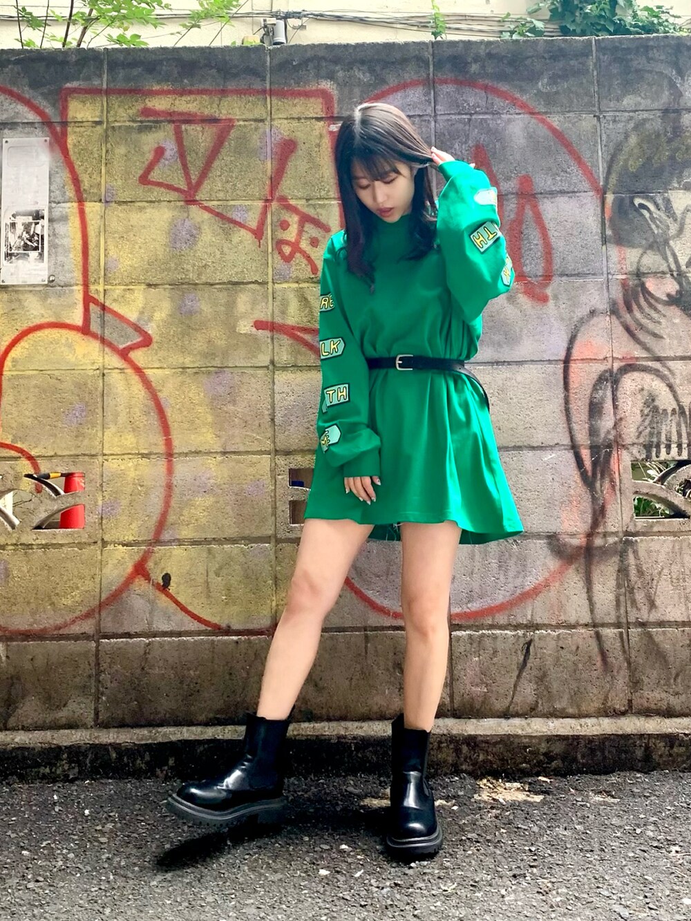ブラック系のダウンジャケット/コート、グリーン系のTシャツ/カットソー、ブラック系のベルトを着用したレディースの秋コーディネートの2枚目の写真