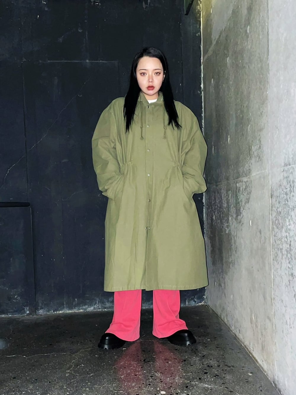 レッド系のスウェットパンツ、ホワイト系のTシャツ/カットソー、グリーン系のモッズコートを着用したレディースの冬コーディネートの3枚目の写真