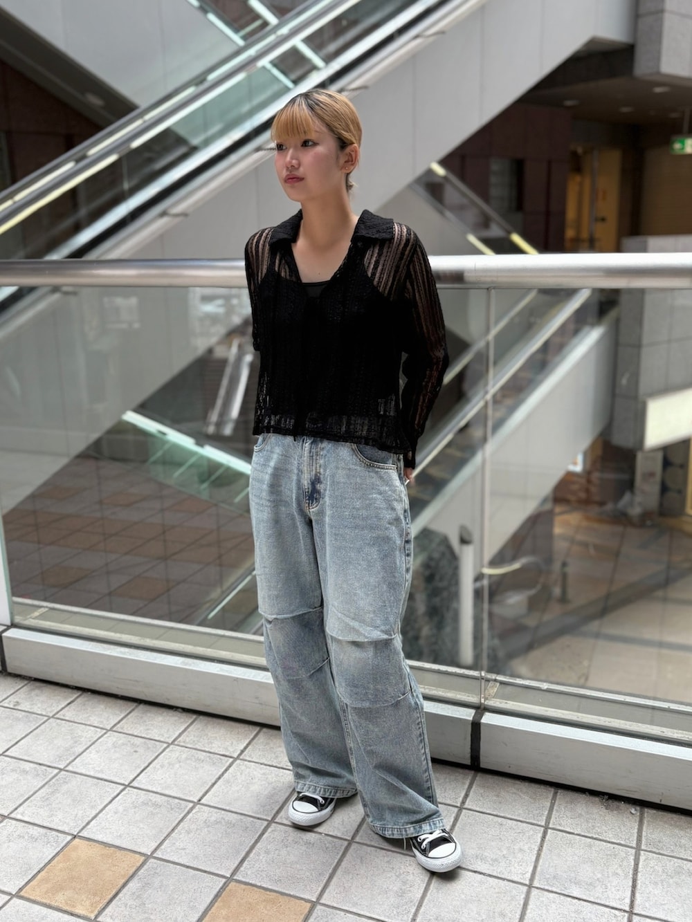 ブラック系のシャツ/ブラウス、ブルー系のデニムパンツを着用したレディースの秋コーディネートの3枚目の写真