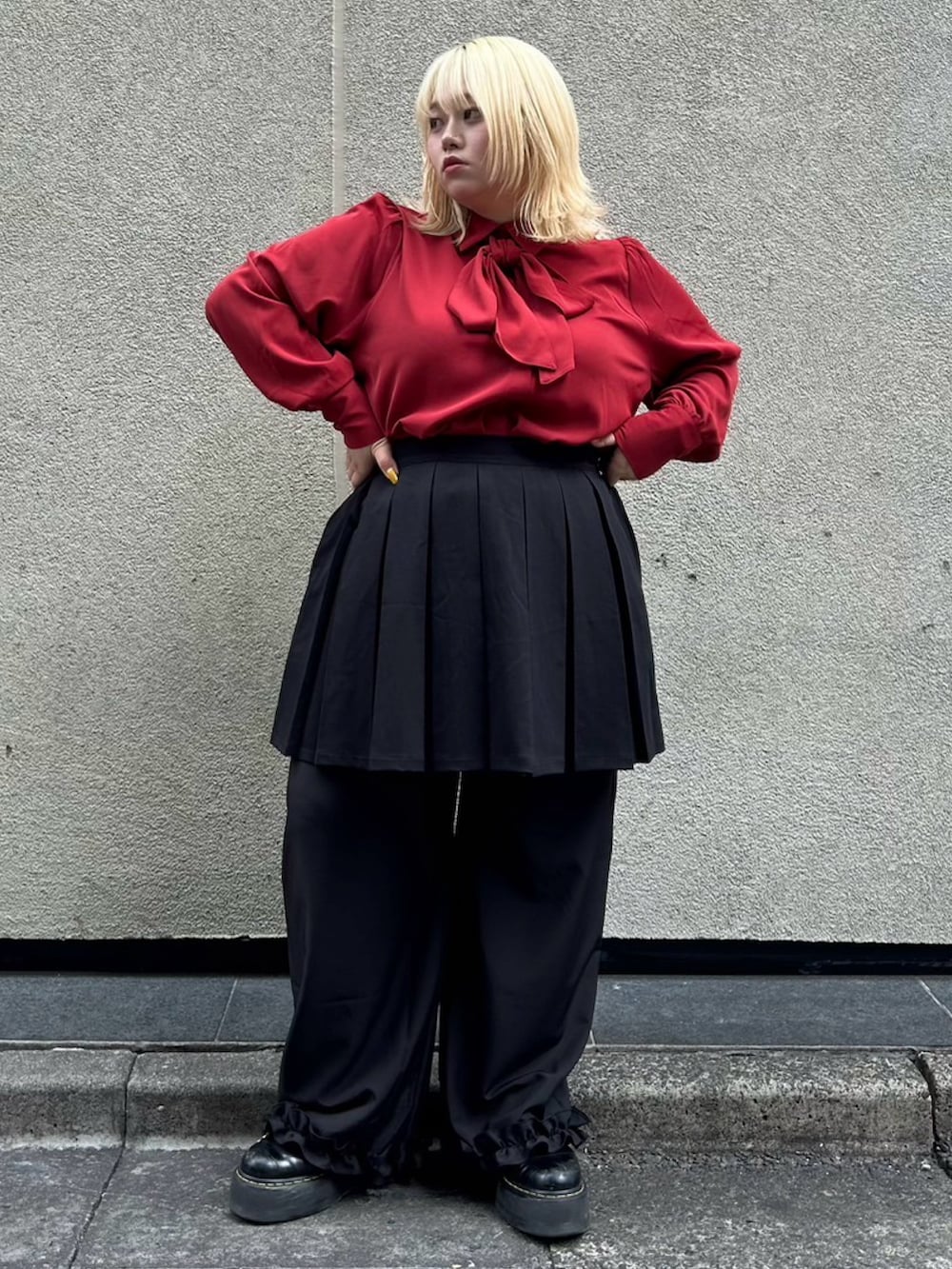 レッド系のシャツ/ブラウス、ブラック系のスカート、ブラック系のスラックスを着用したレディースの秋コーディネートの2枚目の写真