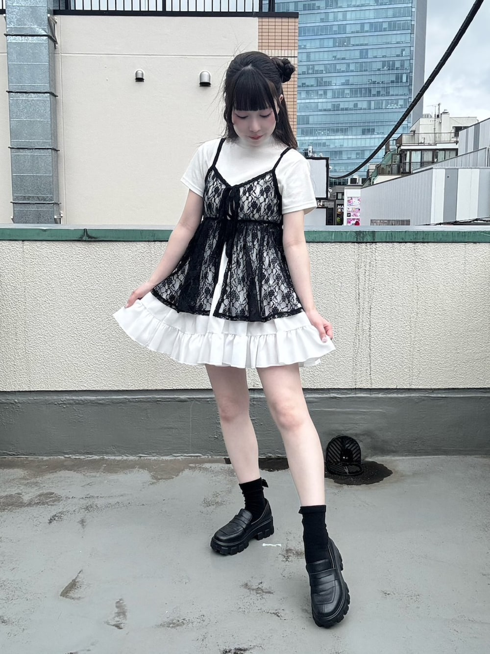 ホワイト系のスカート、ブラック系のワンピース、ホワイト系のTシャツ/カットソーを着用したレディースの夏コーディネートの3枚目の写真