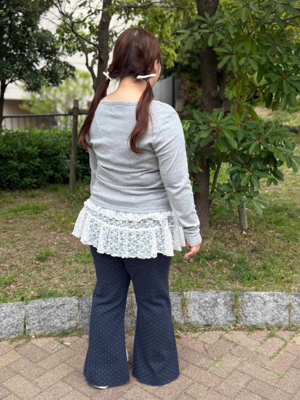 ブルー系のデニムパンツ、ホワイト系のワンピース、グレー系のカーディガン/ボレロを着用したレディースの春コーディネートの4枚目の写真