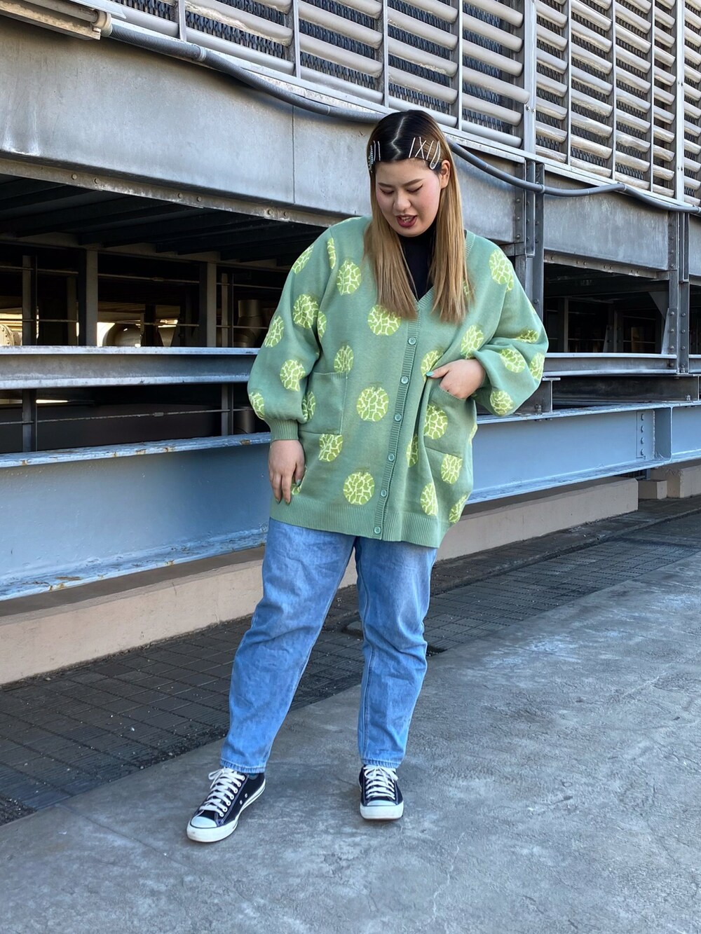 ブルー系のデニムパンツ、グリーン系のカーディガン/ボレロ、ブラック系のTシャツ/カットソーを着用したレディースの冬コーディネートの2枚目の写真