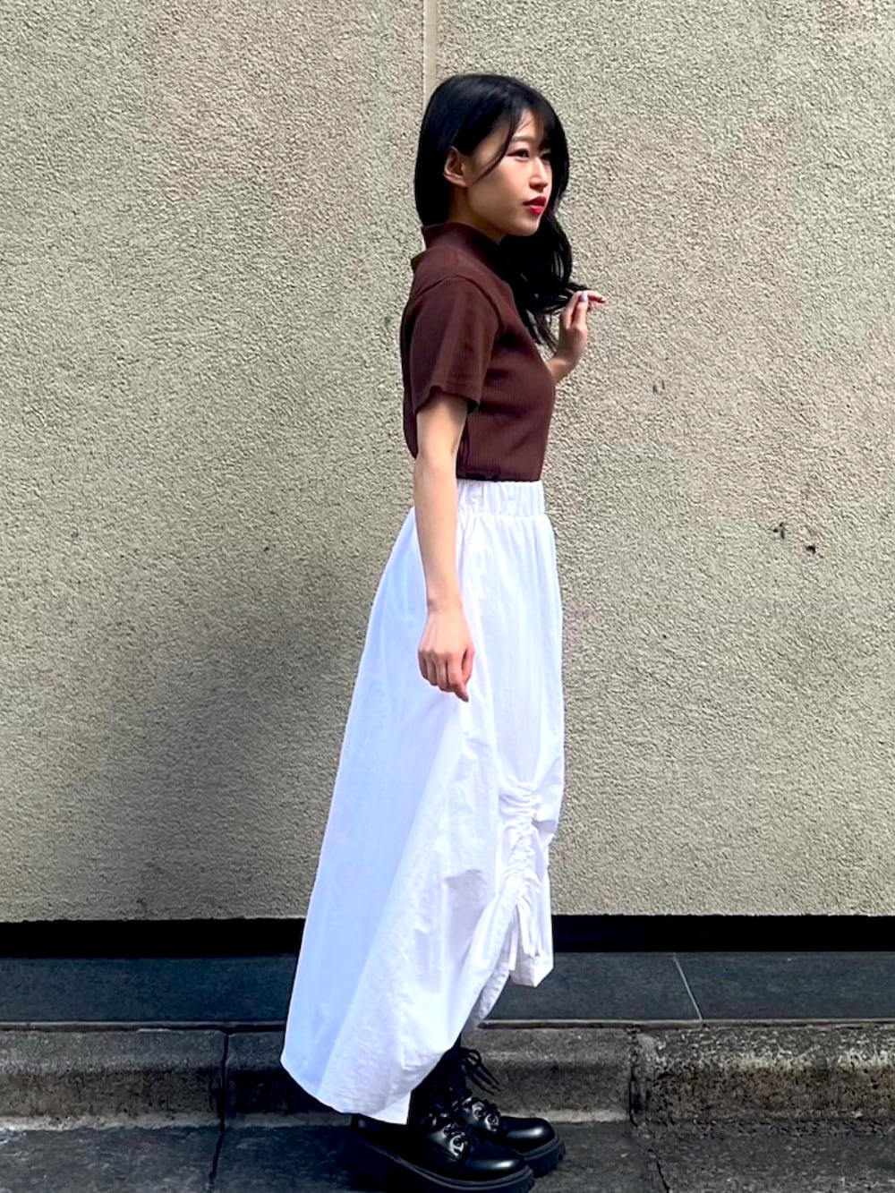 ホワイト系のスカート、ブラウン系のTシャツ/カットソーを着用したレディースの秋コーディネートの2枚目の写真
