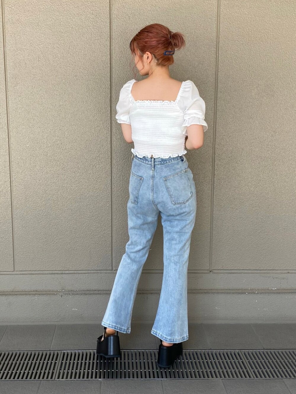 ブルー系のデニムパンツ、ブラック系のサンダル、ホワイト系のシャツ/ブラウスを着用したレディースの夏コーディネートの2枚目の写真