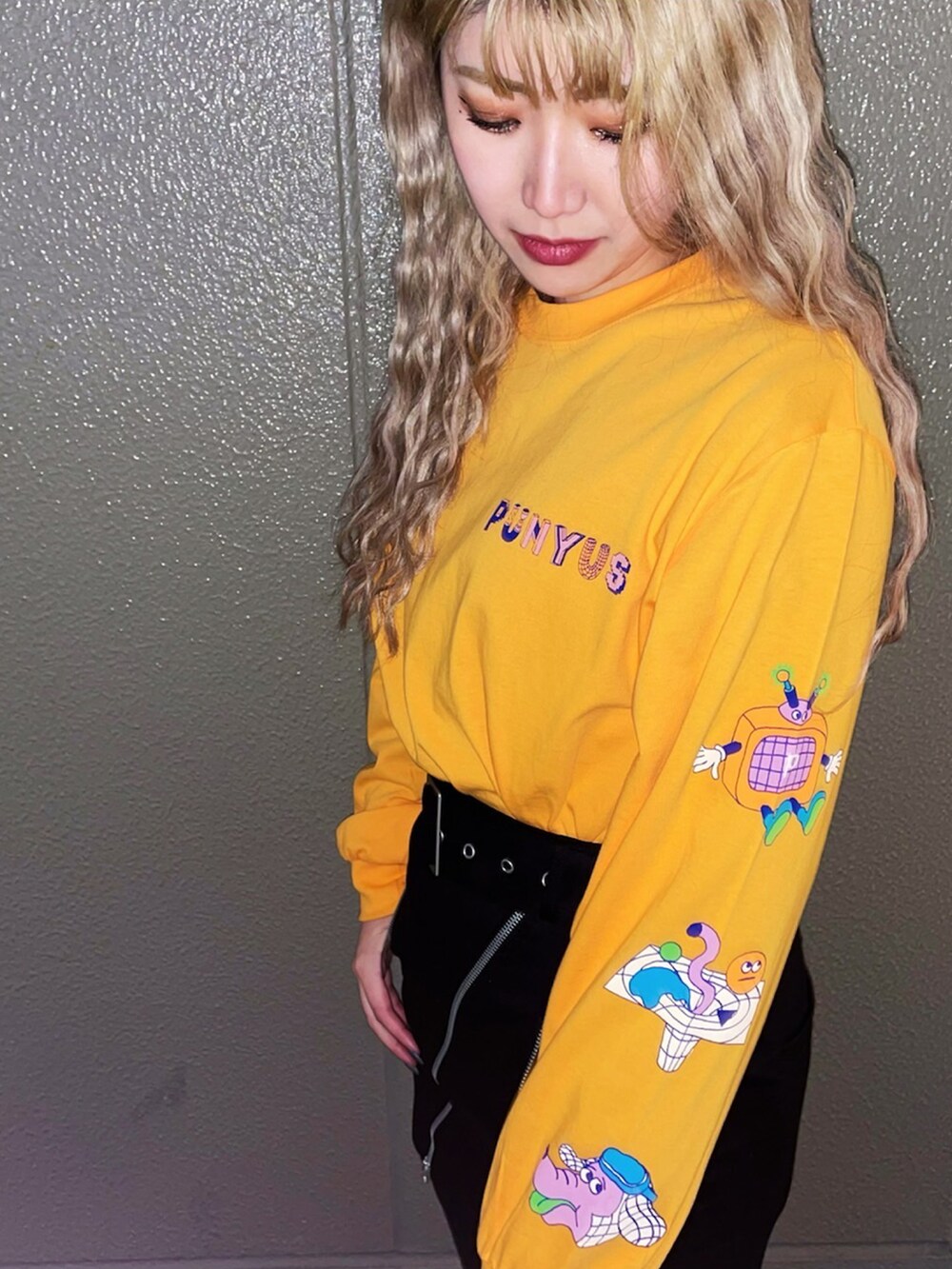 ブラック系のスカート、オレンジ系のTシャツ/カットソー、ブラック系のローファーを着用したレディースの春コーディネートの2枚目の写真