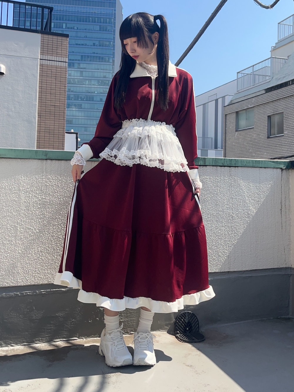 レッド系のワンピース、ホワイト系のスカート、ホワイト系のTシャツ/カットソーを着用したレディースの秋コーディネートの2枚目の写真