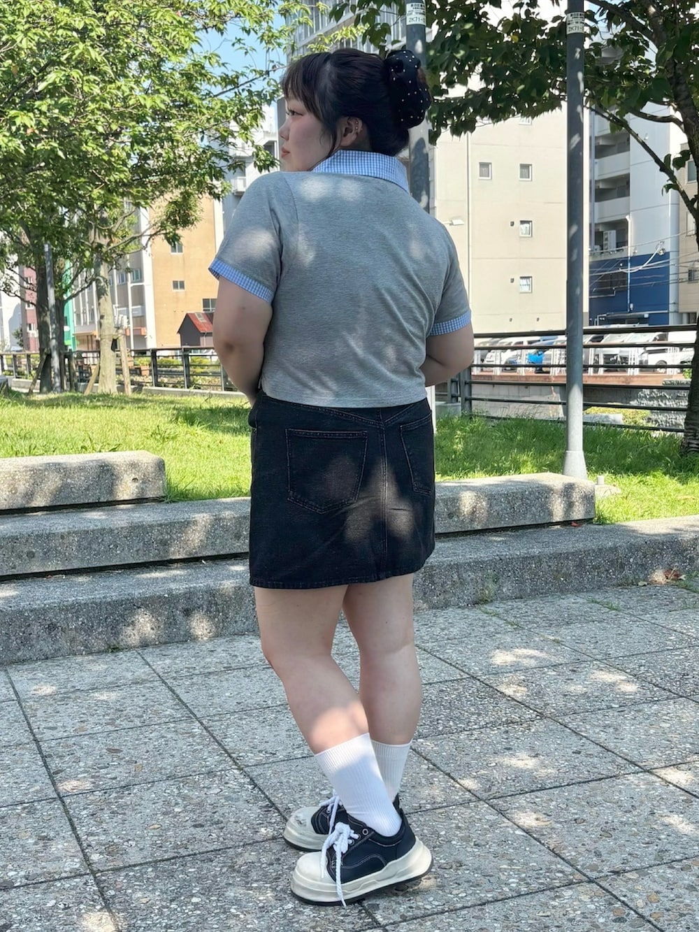 ブラック系のデニムスカート、グレー系のTシャツ/カットソーを着用したレディースの夏コーディネートの4枚目の写真