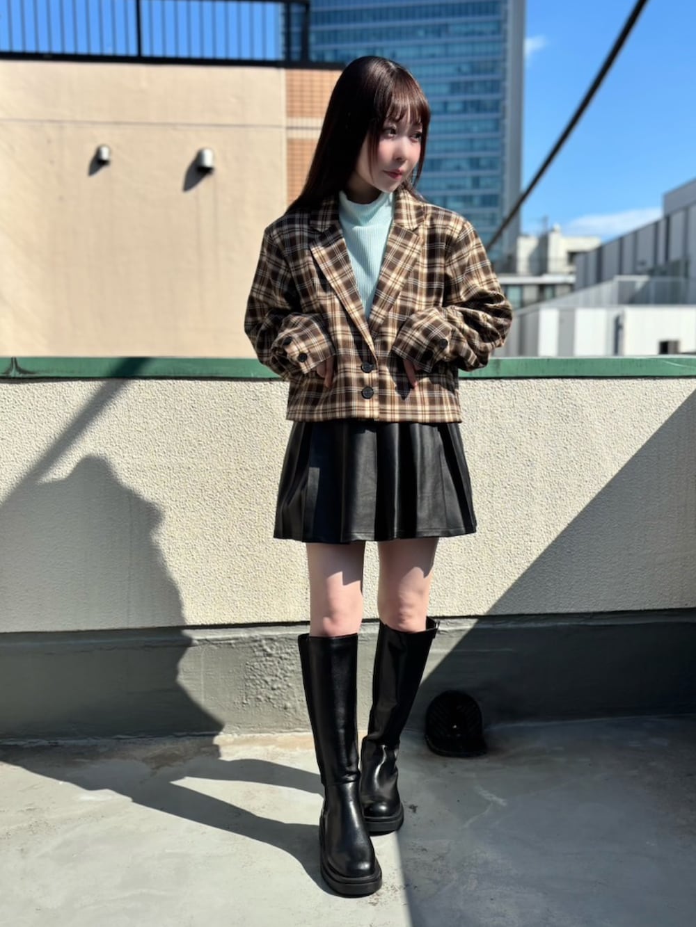 ブラウン系のテーラードジャケット、ブラック系のスカート、ブルー系のTシャツ/カットソーを着用したレディースの秋コーディネートの2枚目の写真