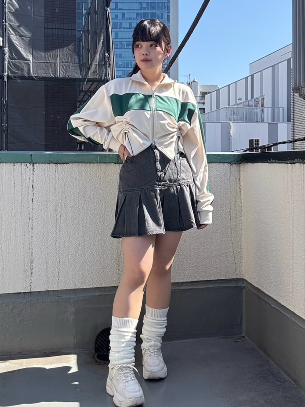 ブラック系のデニムスカート、ホワイト系のジャージを着用したレディースの春コーディネートの2枚目の写真