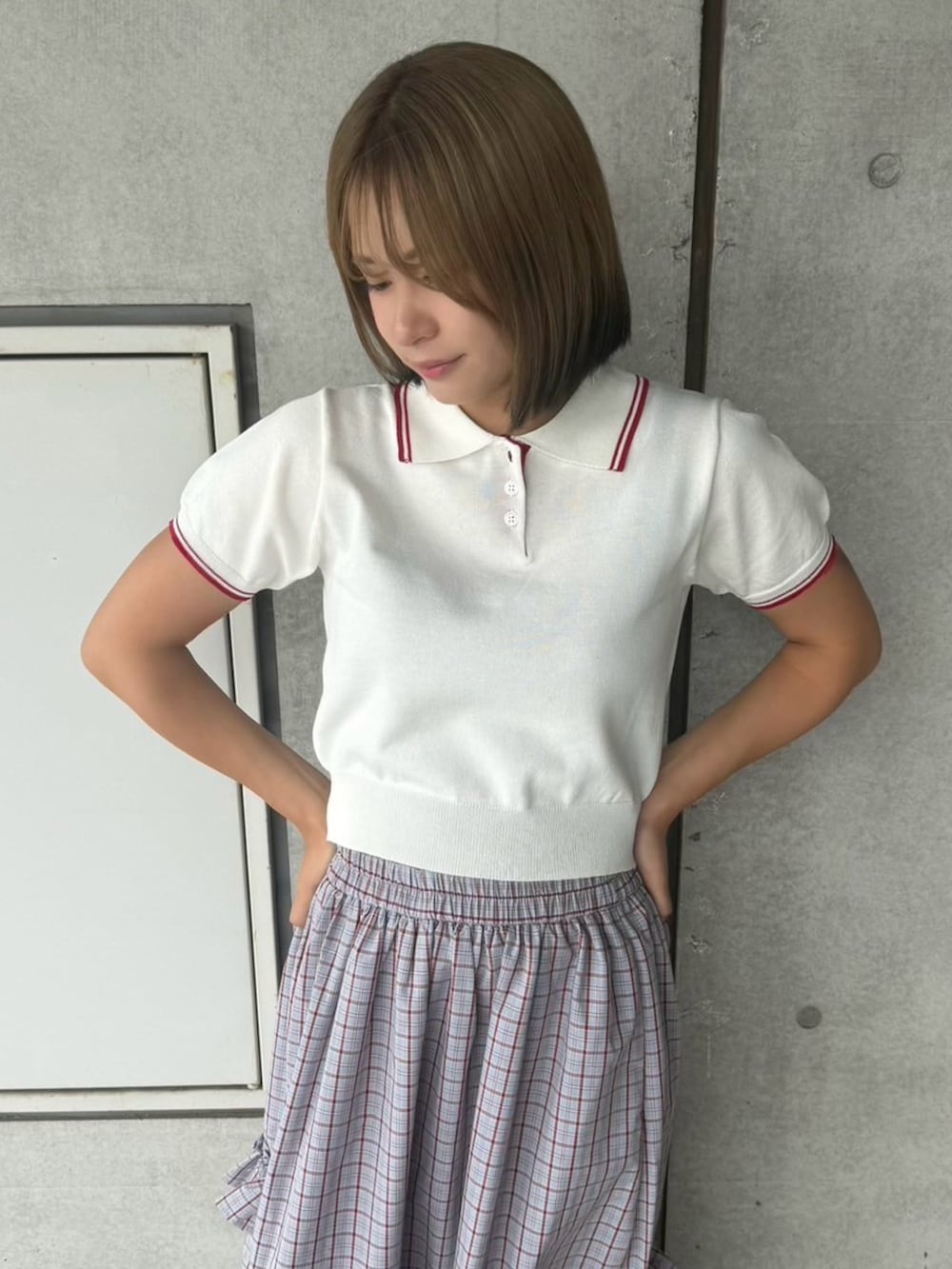 ブルー系のスカート、ホワイト系のポロシャツを着用したレディースの夏コーディネートの4枚目の写真
