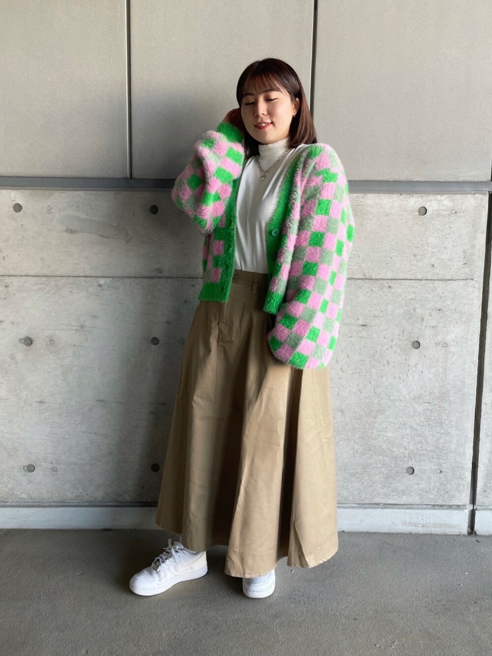 グリーン系のカーディガン/ボレロ、ホワイト系のTシャツ/カットソー、ベージュ系のスカートを着用したレディースの冬コーディネートの3枚目の写真