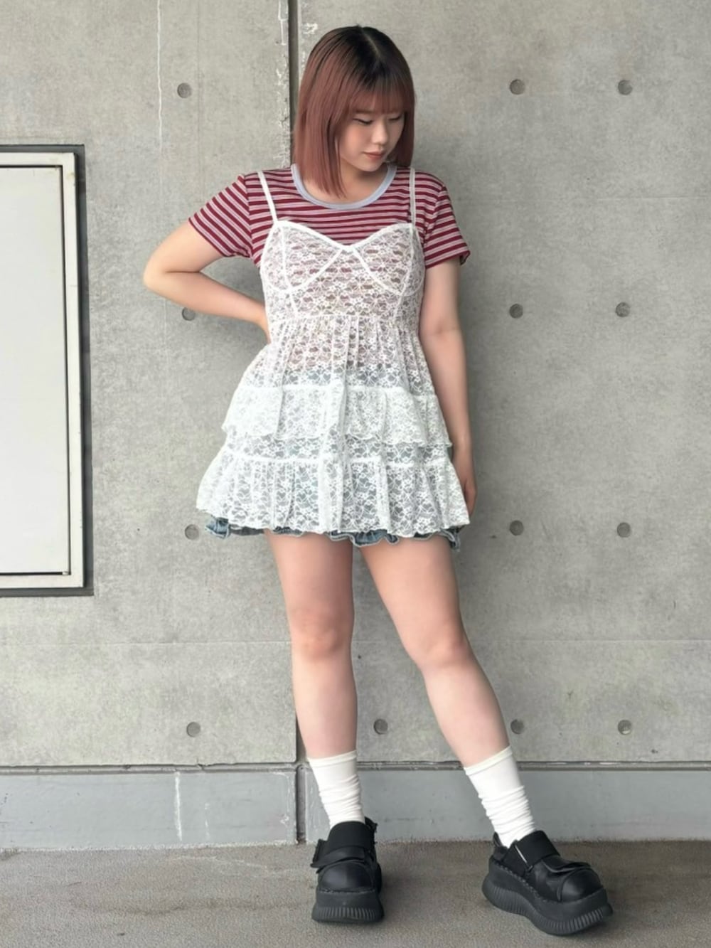ブルー系のデニムスカート、レッド系のTシャツ/カットソー、ホワイト系のワンピースを着用したレディースの春コーディネートの2枚目の写真