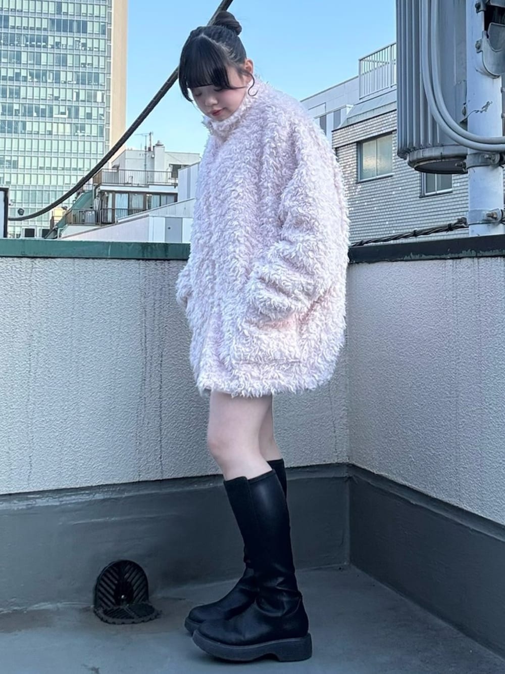 ピンク系のブルゾン、グレー系のニット/セーター、グレー系のスカートを着用したレディースの冬コーディネートの2枚目の写真