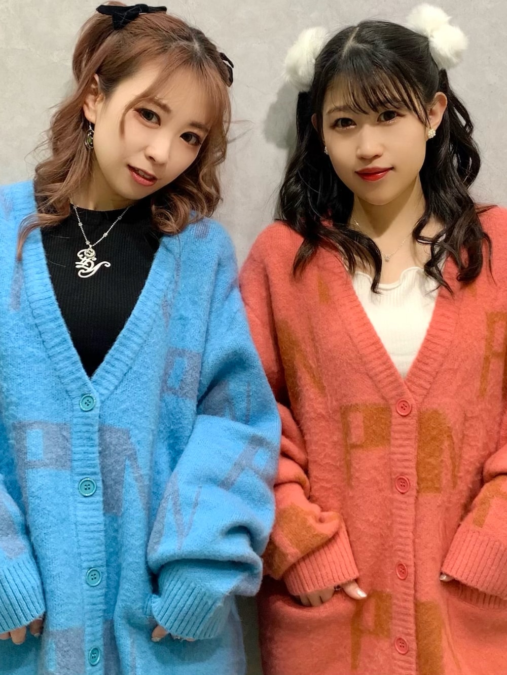 ブルー系のカーディガン/ボレロ、ピンク系のカーディガン/ボレロ、ブラック系のスカートを着用したレディースの冬コーディネートの2枚目の写真