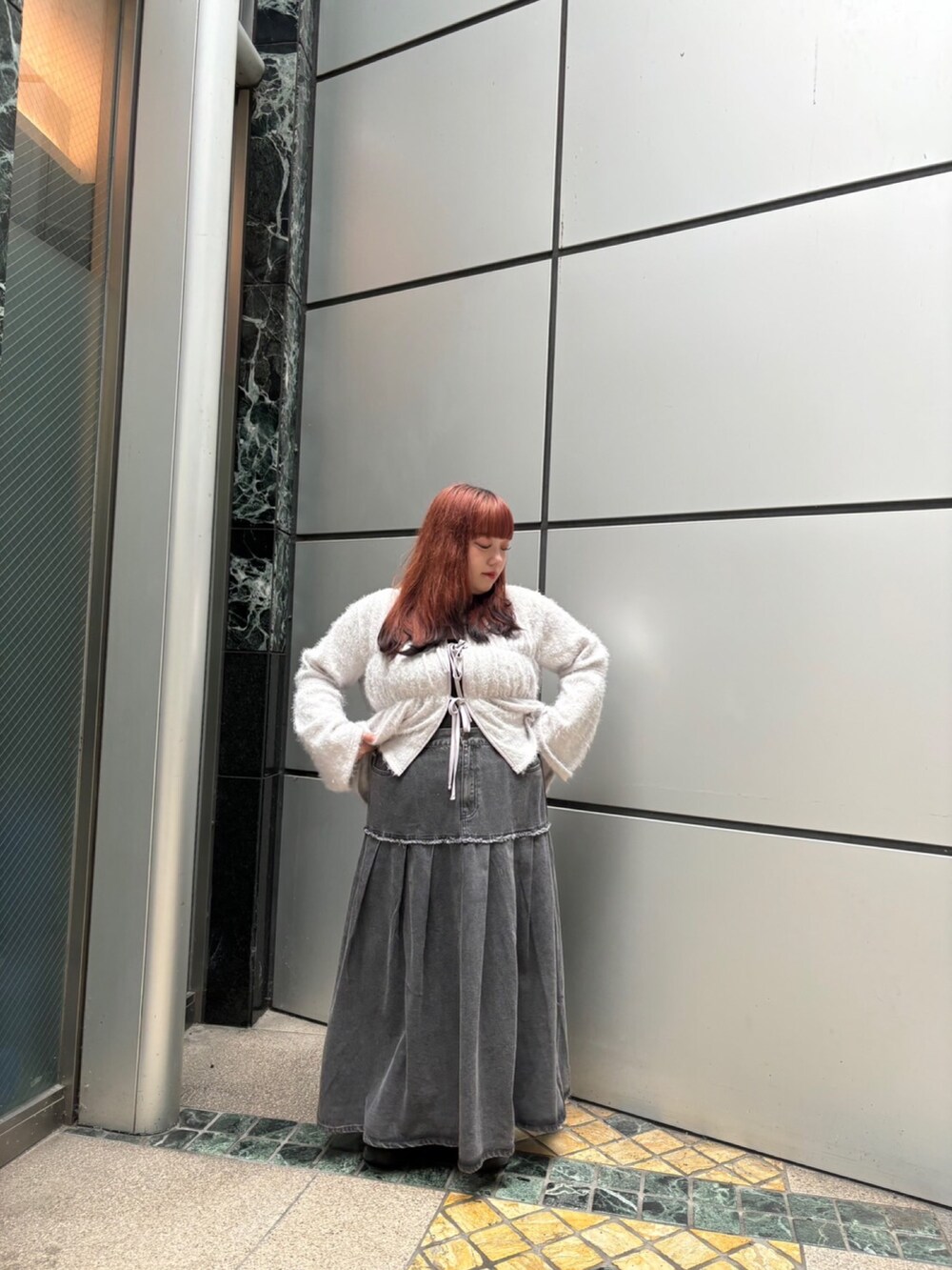 グレー系のカーディガン/ボレロ、ブラック系のデニムスカートを着用したレディースの秋コーディネートの2枚目の写真