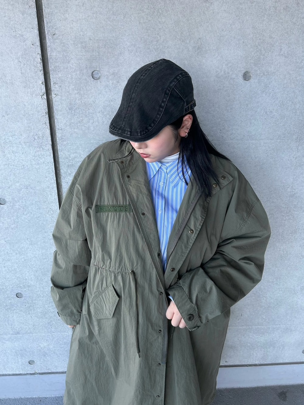 グリーン系のモッズコート、ブルー系のシャツ/ブラウス、ブラック系のデニムパンツを着用したレディースの春コーディネートの4枚目の写真