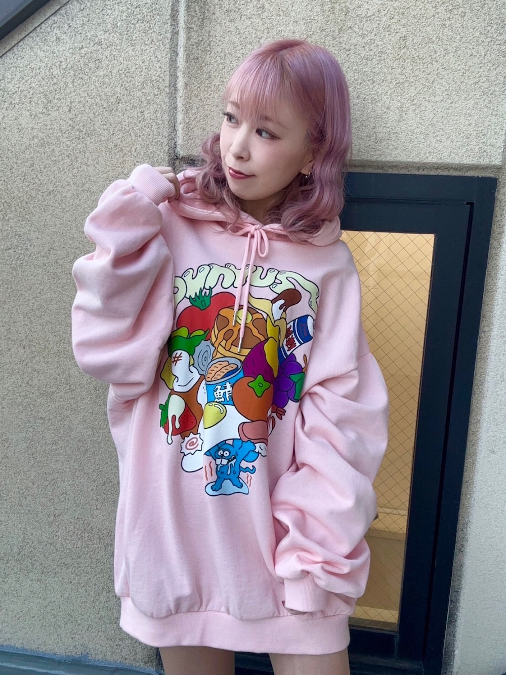 グリーン系のナイロンジャケット、ピンク系のパーカーを着用したレディースの冬コーディネートの2枚目の写真