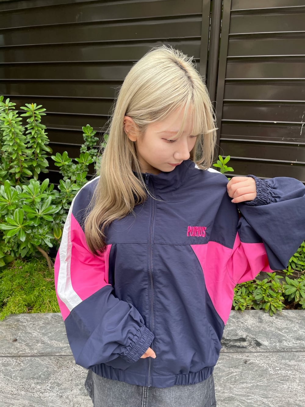 ブルー系のナイロンジャケット、ブラック系のデニムスカートを着用したレディースの秋コーディネートの4枚目の写真