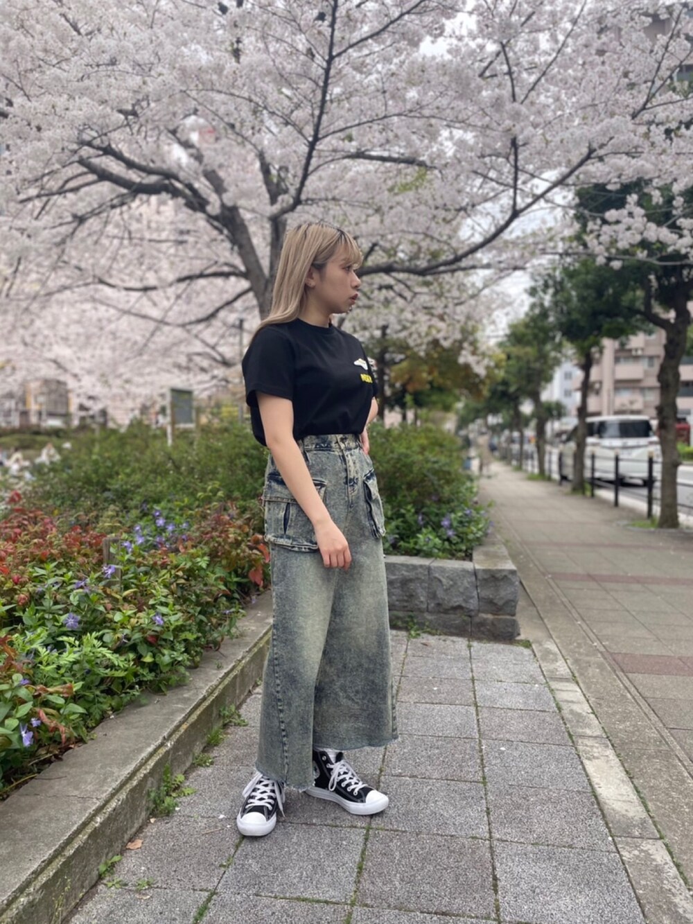 ブラック系のTシャツ/カットソー、ブルー系のデニムスカートを着用したレディースの春コーディネートの3枚目の写真