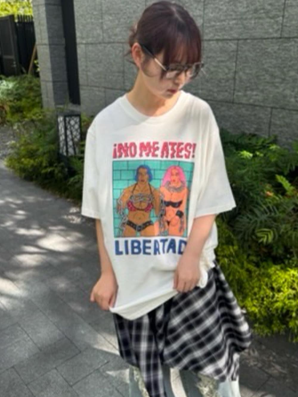 ブラック系のワンピース、ホワイト系のTシャツ/カットソー、ブルー系のデニムパンツを着用したレディースの夏コーディネートの3枚目の写真