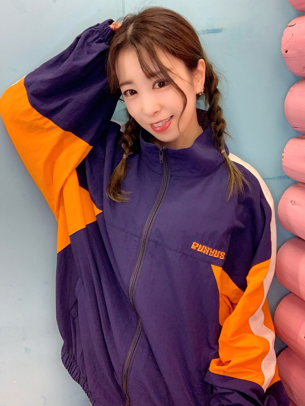 ブルー系のナイロンジャケット、ブルー系のデニムパンツ、ホワイト系のスニーカーを着用したレディースの秋コーディネートの2枚目の写真