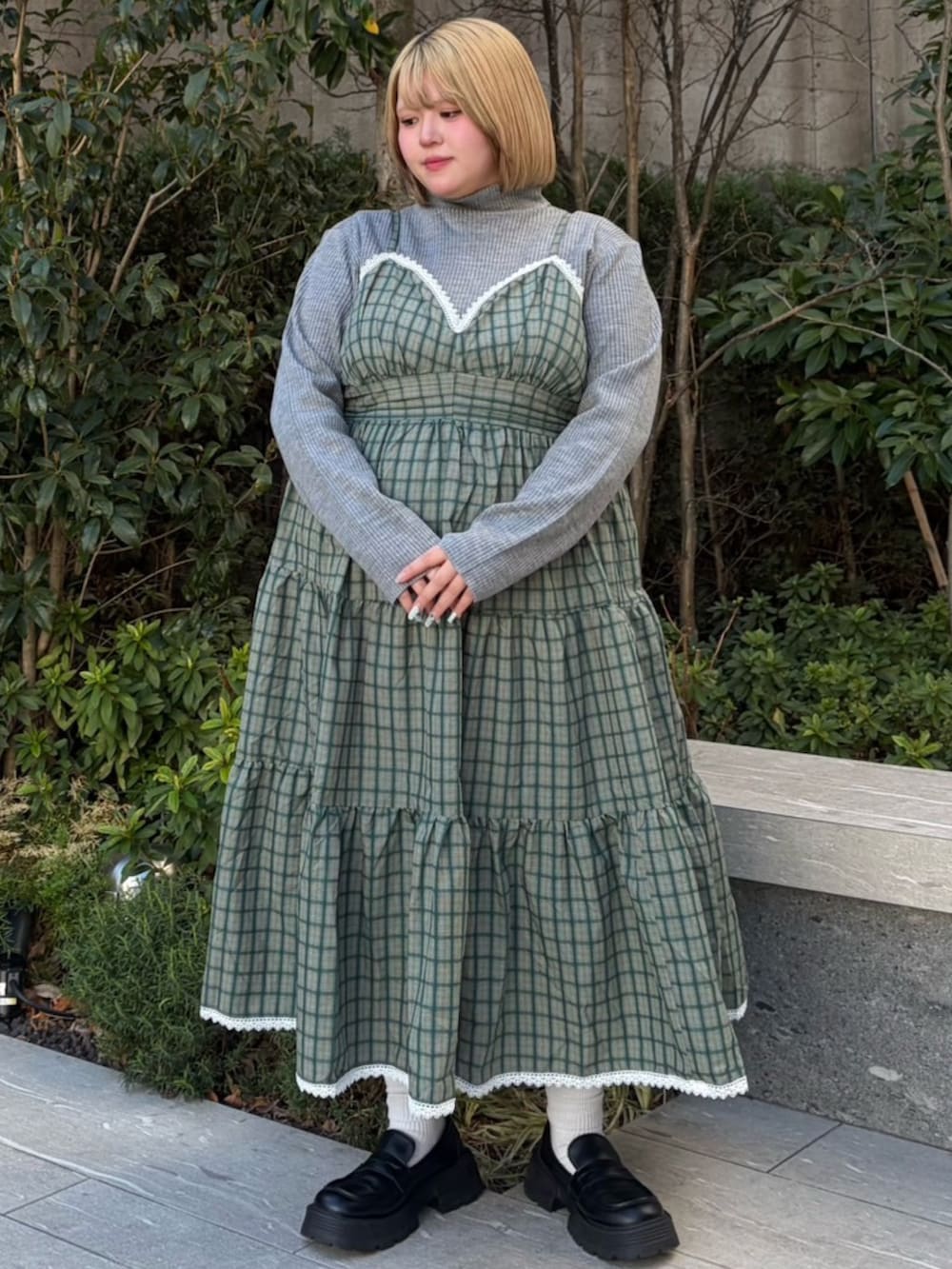 グリーン系のワンピース、グレー系のニット/セーターを着用したレディースの春コーディネートの2枚目の写真