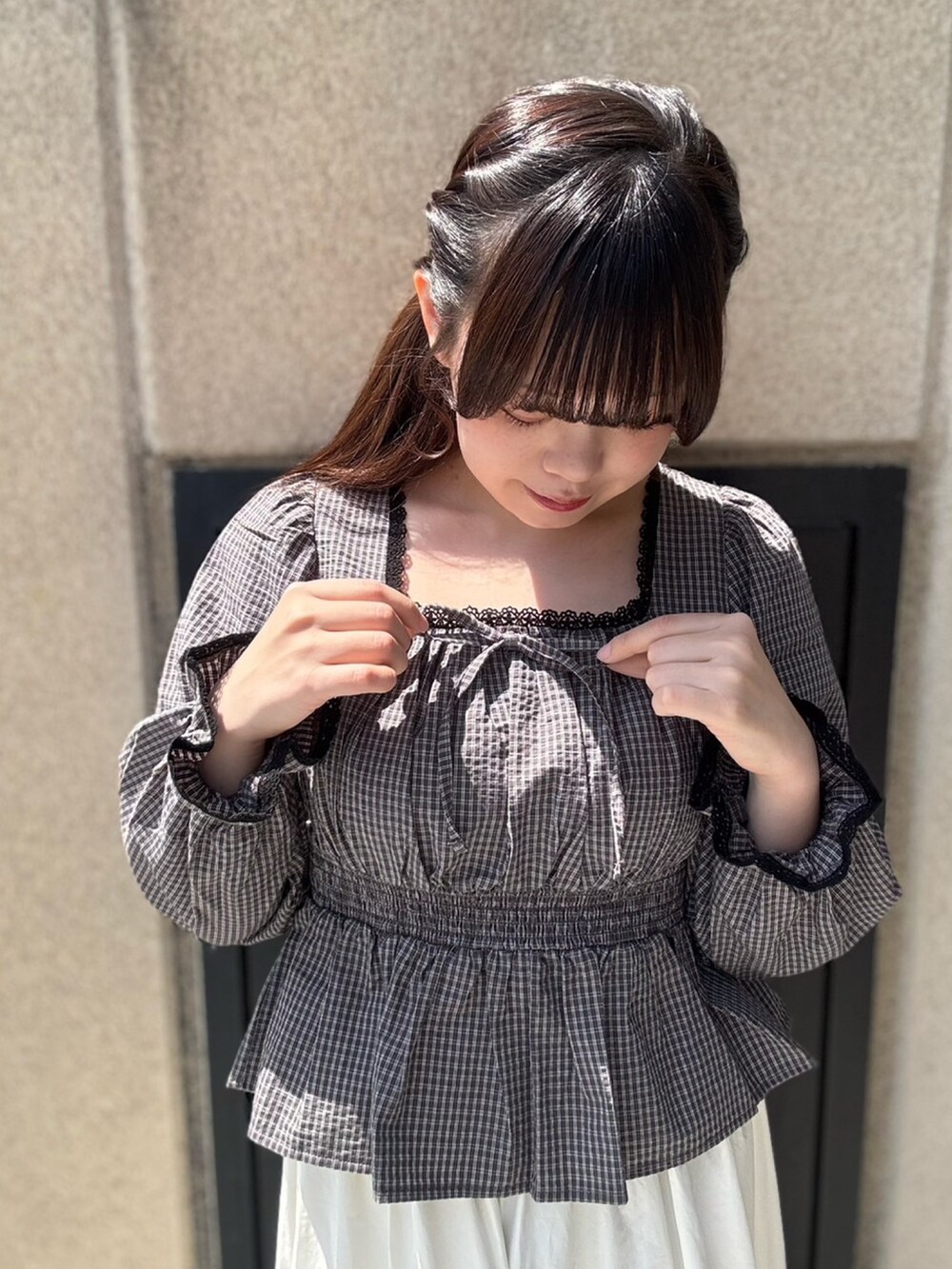 ホワイト系のスカート、ブラック系のシャツ/ブラウスを着用したレディースの春コーディネートの5枚目の写真