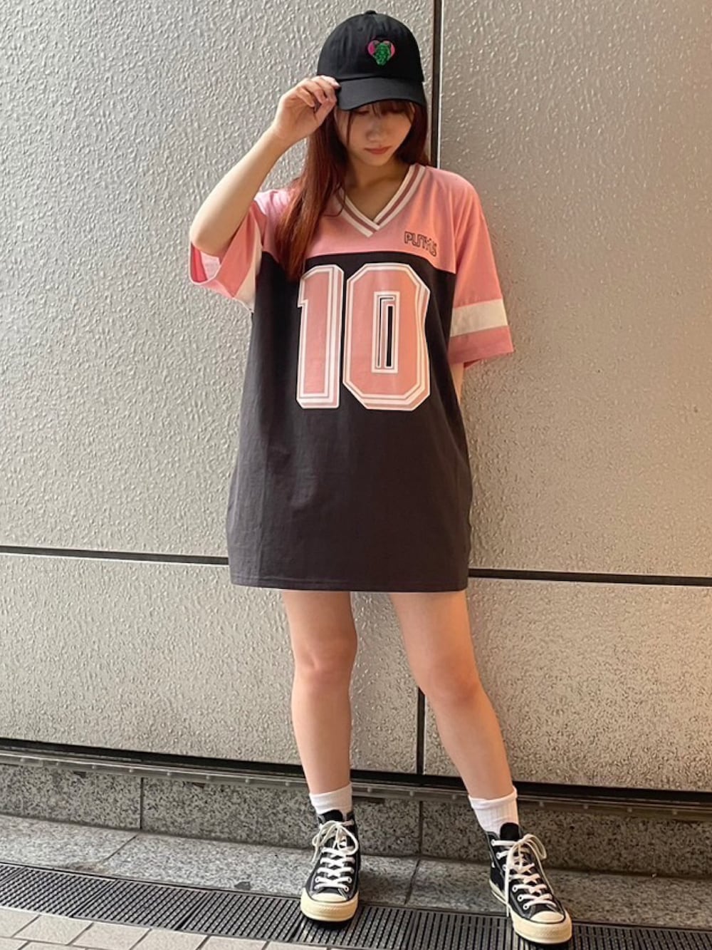 ピンク系のTシャツ/カットソー、ブラック系のキャップを着用したレディースの夏コーディネートの3枚目の写真