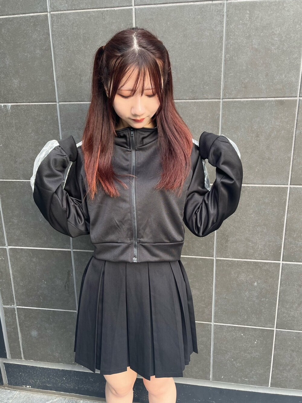 ブラック系のジャージ、ブラック系のスカートを着用したレディースの夏コーディネートの2枚目の写真