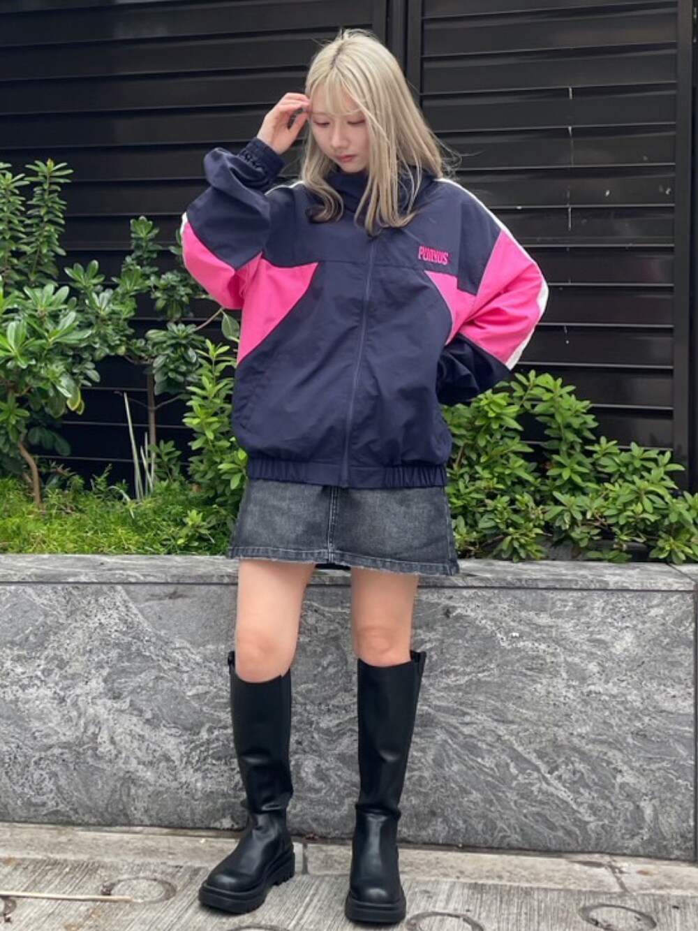 ブルー系のナイロンジャケット、ブラック系のデニムスカートを着用したレディースの秋コーディネートの2枚目の写真