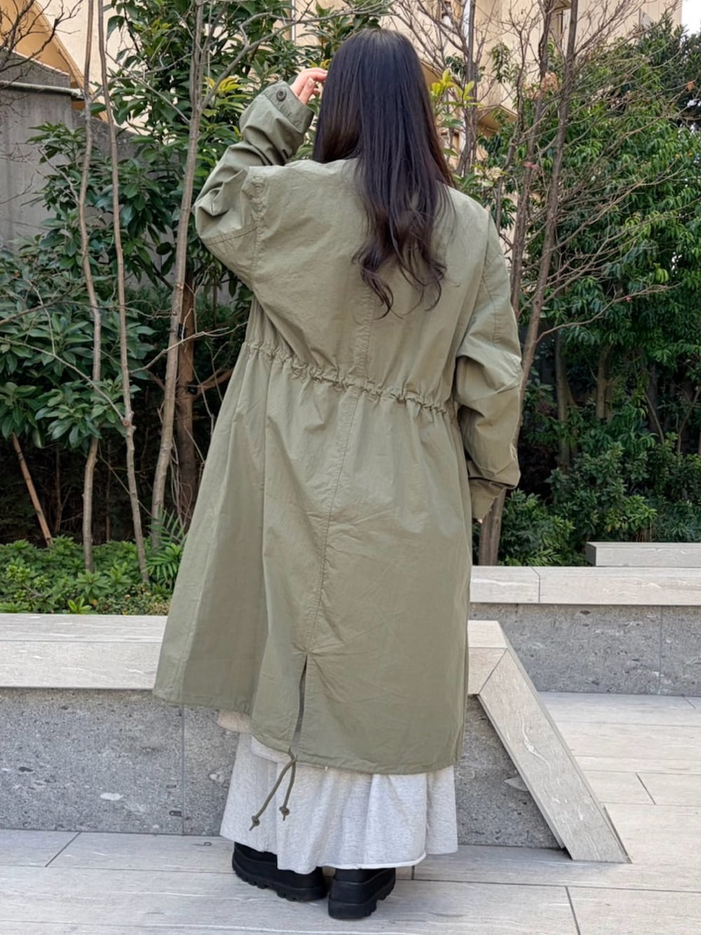 イエロー系のTシャツ/カットソー、グリーン系のモッズコート、グレー系のスカートを着用したレディースの冬コーディネートの7枚目の写真