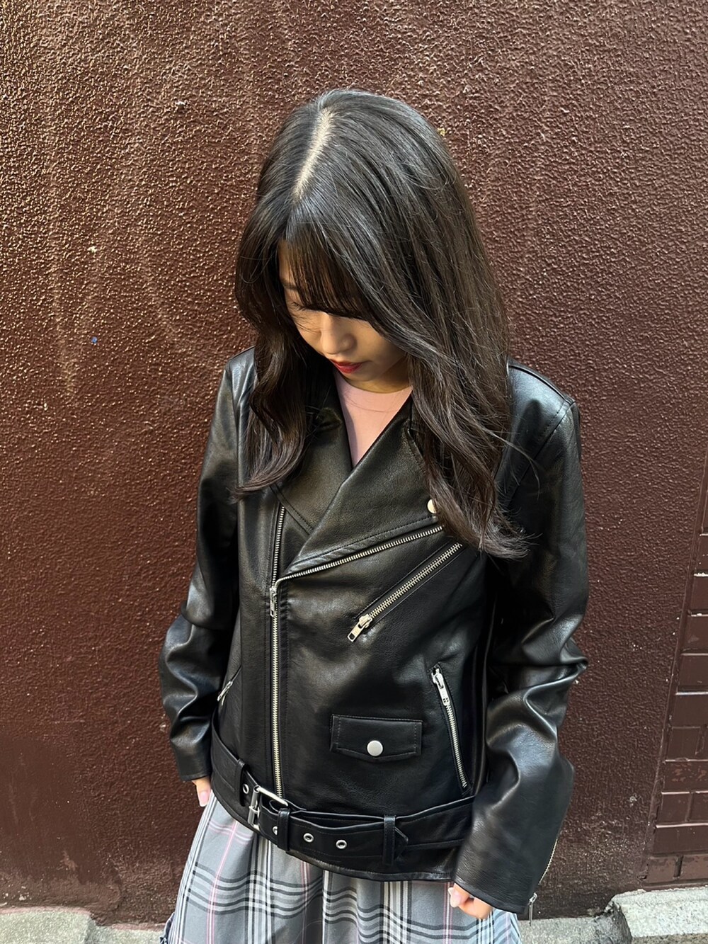 グレー系のスカート、ブラック系のライダースジャケットを着用したレディースの秋コーディネートの4枚目の写真