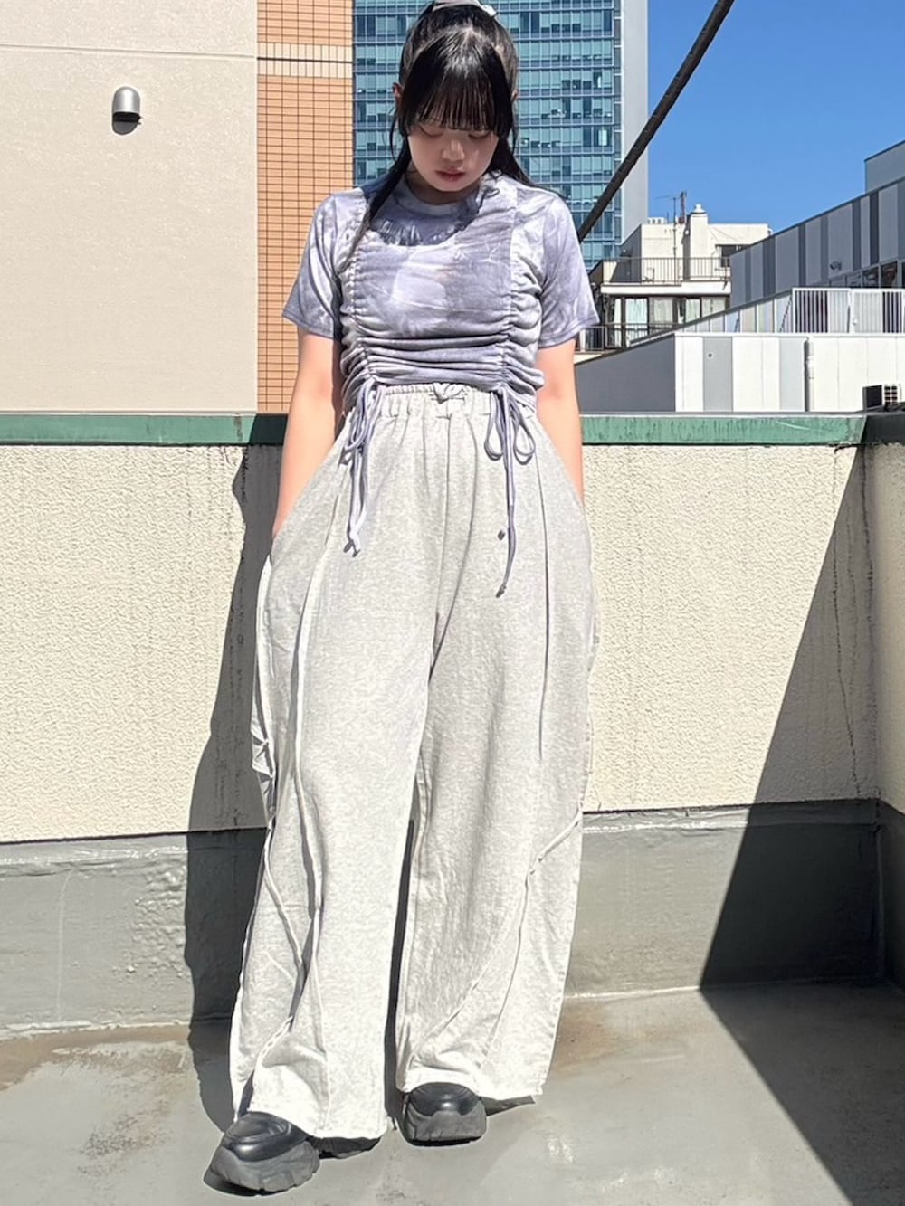 グレー系のスウェットパンツ、パープル系のTシャツ/カットソーを着用したレディースの夏コーディネートの2枚目の写真