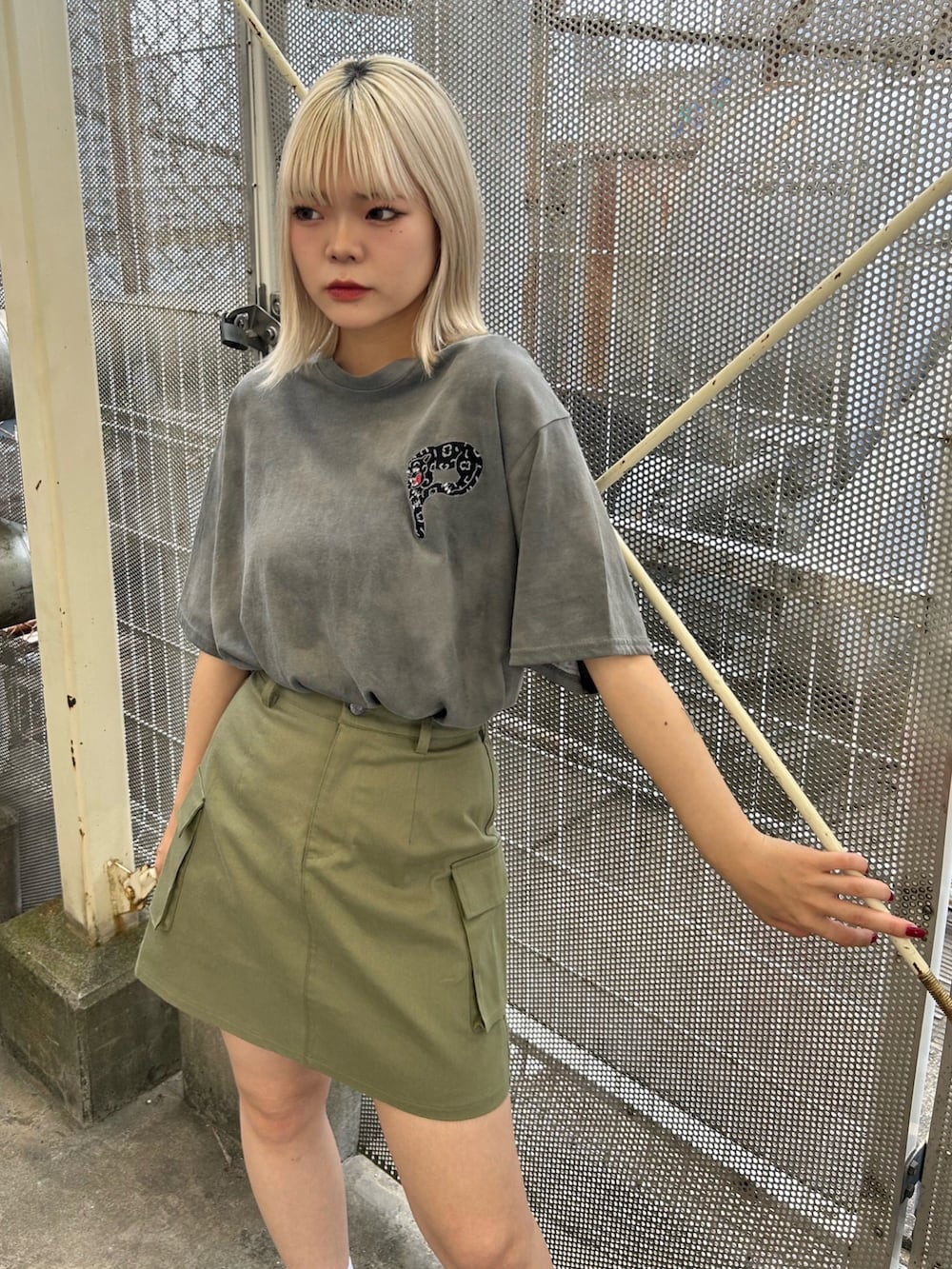 グリーン系のスカート、ブラック系のTシャツ/カットソー、ブラック系のサンダルを着用したレディースの夏コーディネートの3枚目の写真