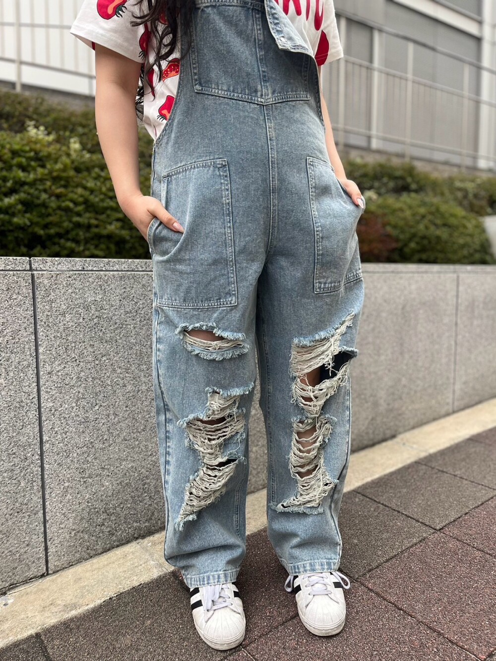 ブルー系のサロペット/オーバーオール、レッド系のTシャツ/カットソーを着用したレディースの春コーディネートの4枚目の写真