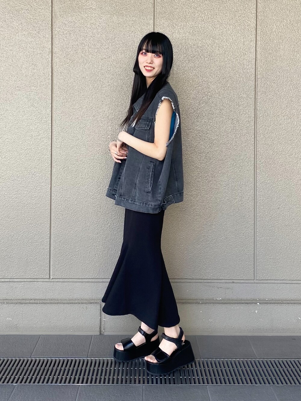ブラック系のサンダル、ブラック系のスカート、ブルー系のタンクトップを着用したレディースの夏コーディネートの2枚目の写真
