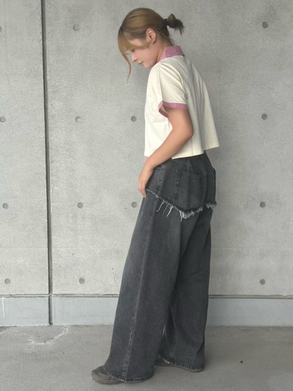 ブラック系のデニムパンツ、ホワイト系のTシャツ/カットソーを着用したレディースの夏コーディネートの3枚目の写真