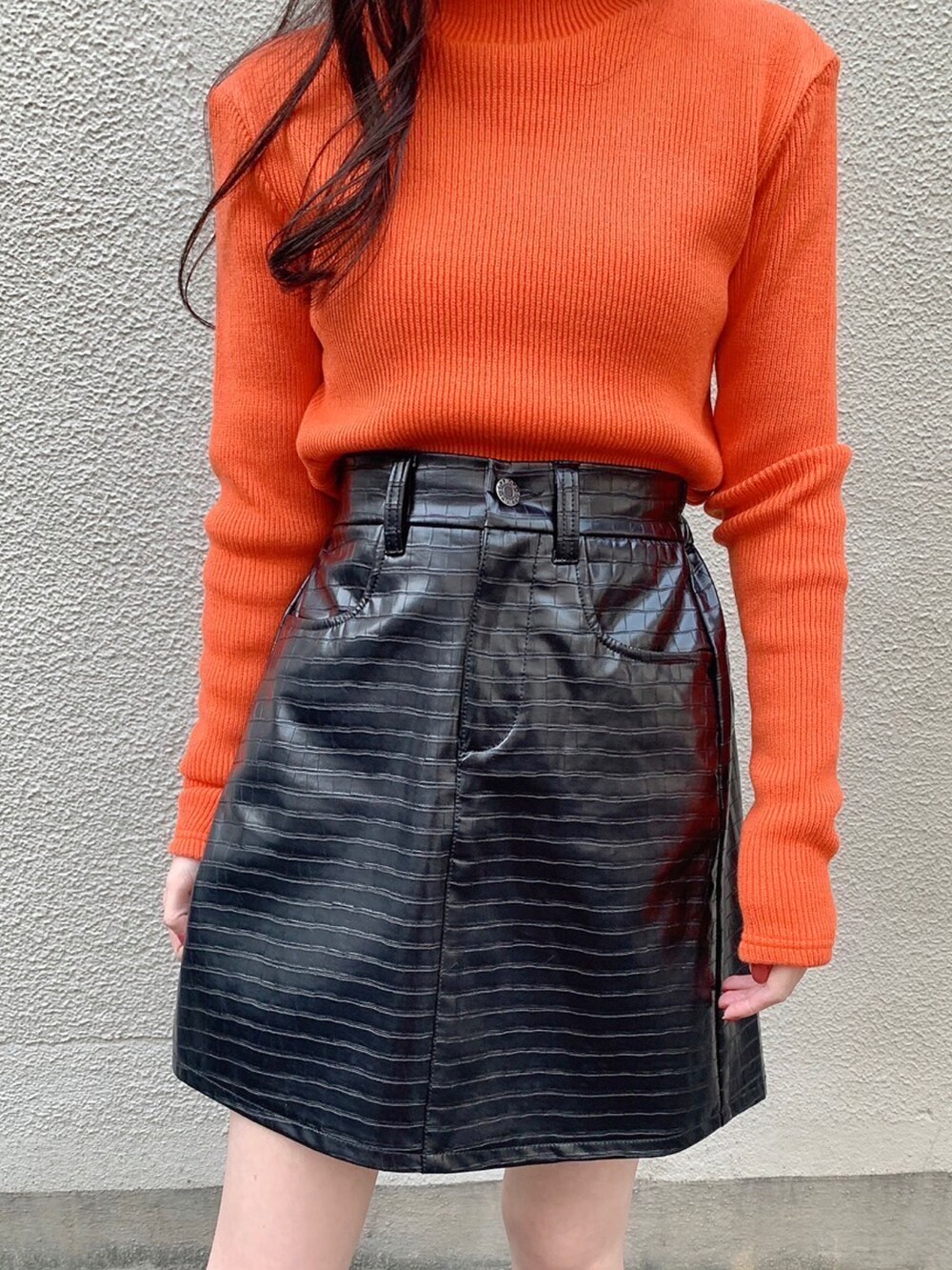 ブラック系のスカート、グリーン系のMA-1、オレンジ系のニット/セーターを着用したレディースの冬コーディネートの3枚目の写真