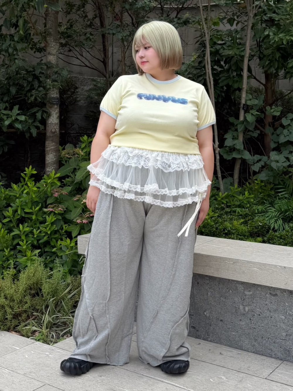 グレー系のスウェットパンツ、ホワイト系のスカート、イエロー系のTシャツ/カットソーを着用したレディースの夏コーディネートの2枚目の写真