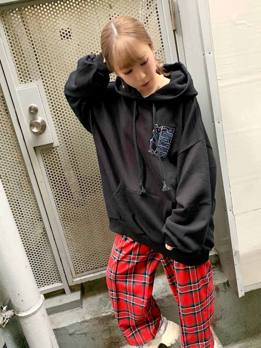 ブラック系のパーカー、レッド系のその他パンツを着用したレディースの秋コーディネートの3枚目の写真