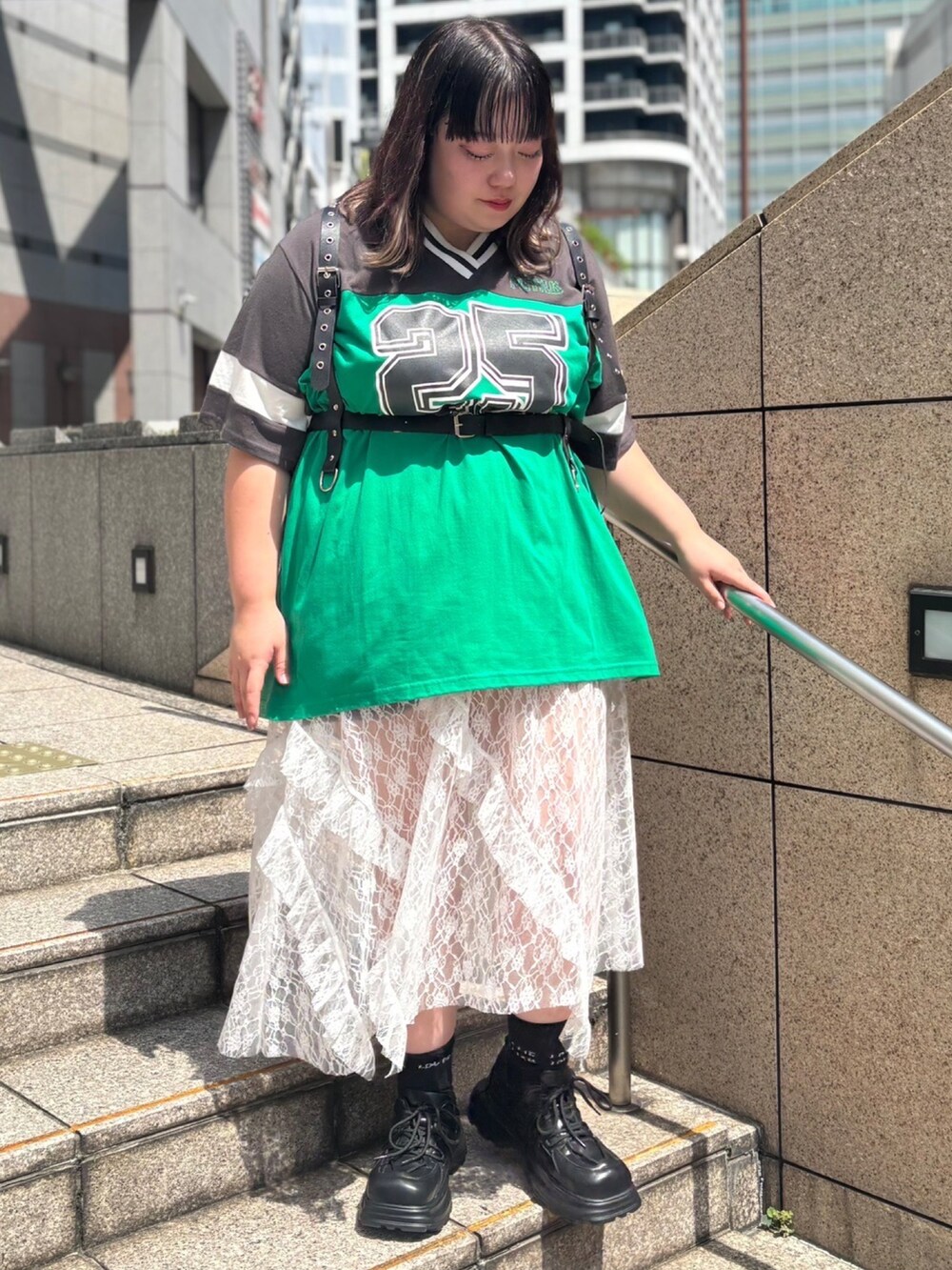 ホワイト系のスカート、ブラック系のTシャツ/カットソー、ブラック系のベルトを着用したレディースの夏コーディネートの2枚目の写真