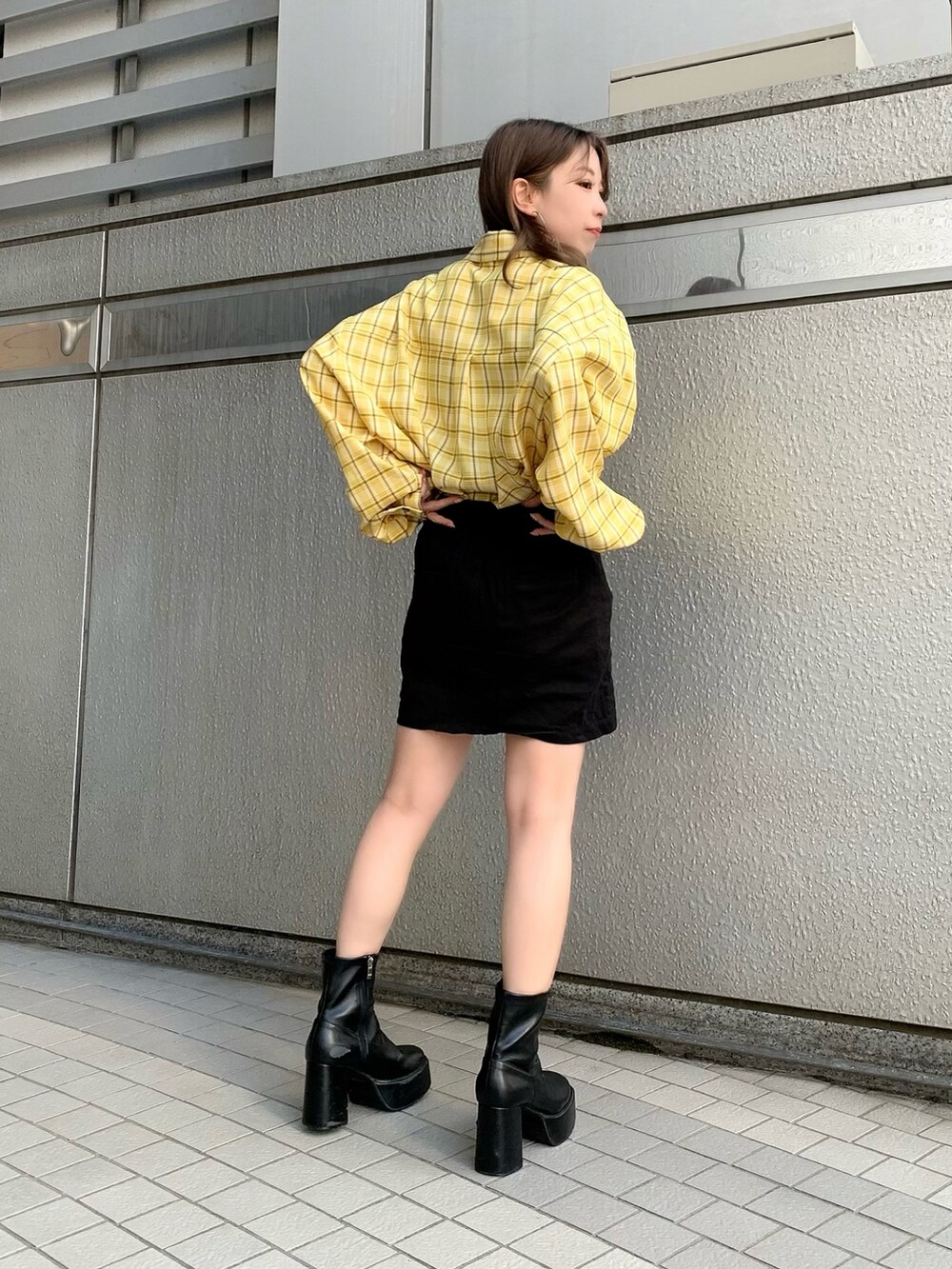 イエロー系のシャツ/ブラウス、ブラック系のスカートを着用したレディースの冬コーディネートの2枚目の写真