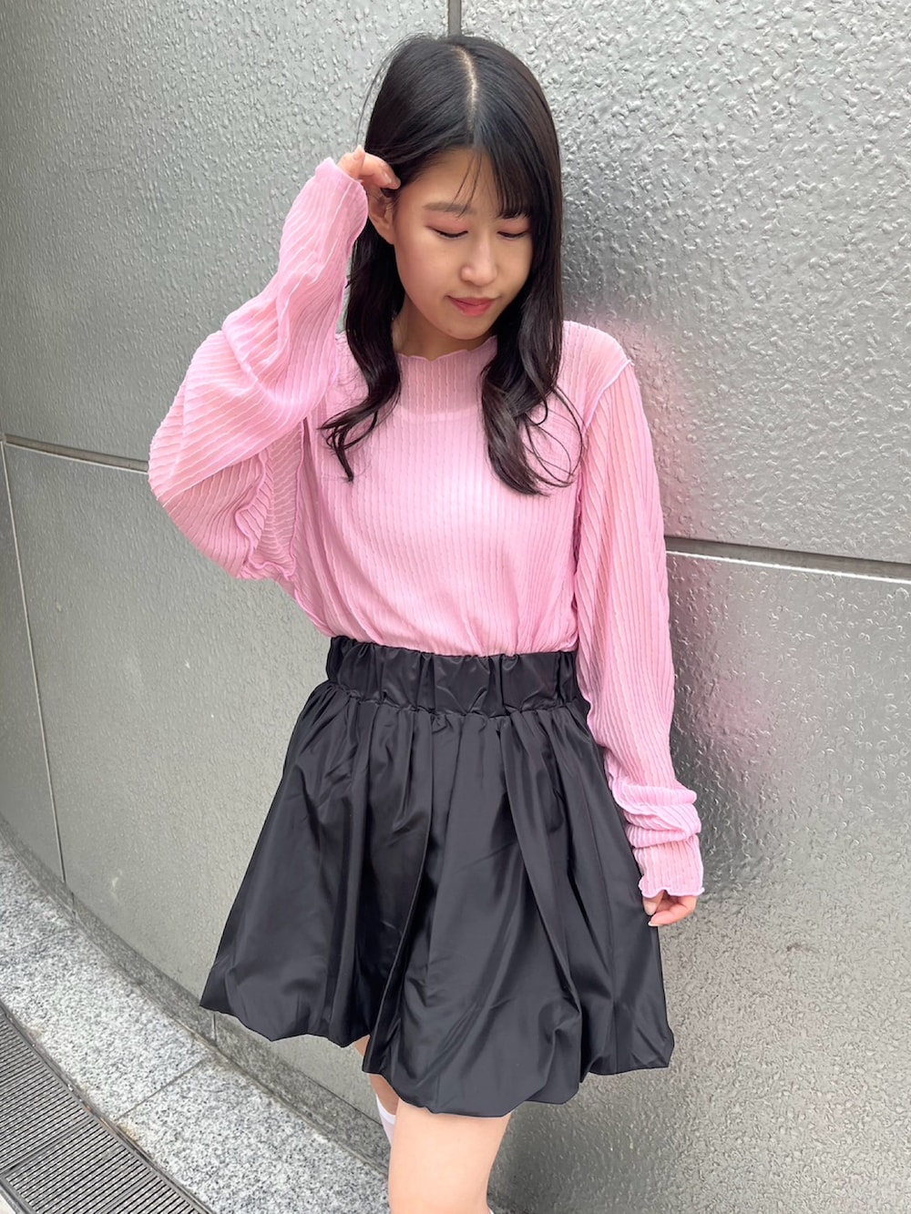 ブラック系のスカート、ピンク系のTシャツ/カットソーを着用したレディースの夏コーディネートの3枚目の写真