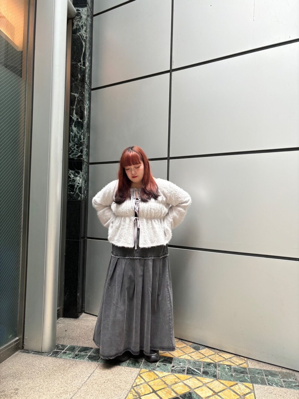 グレー系のカーディガン/ボレロ、ブラック系のデニムスカートを着用したレディースの秋コーディネートの3枚目の写真